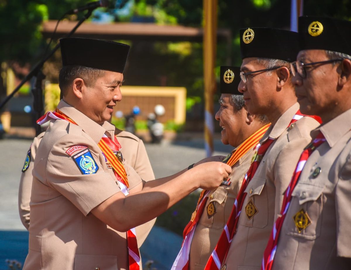 Gubernur NTB Lalu Muhamad Iqbal memberikan lencana penghargaan pramuka.