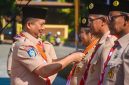 Gubernur NTB Lalu Muhamad Iqbal memberikan lencana penghargaan pramuka.