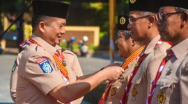 Gubernur NTB Lalu Muhamad Iqbal memberikan lencana penghargaan pramuka.
